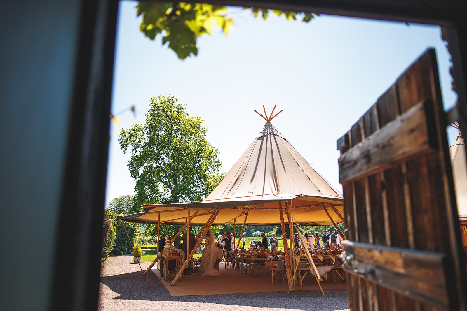 A Giant Hat with sides up, seen through an old barn door on a sunny wedding day