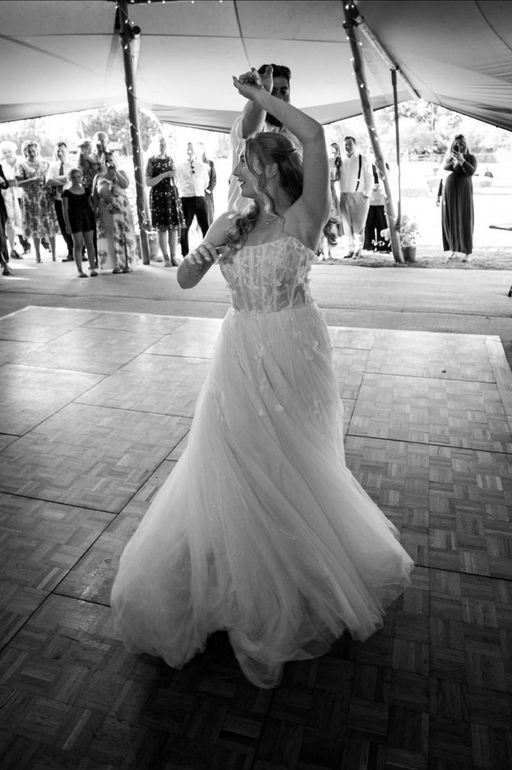 Louise twirling during her first dance with Luke on the dancefloor under their tipi, guests watching