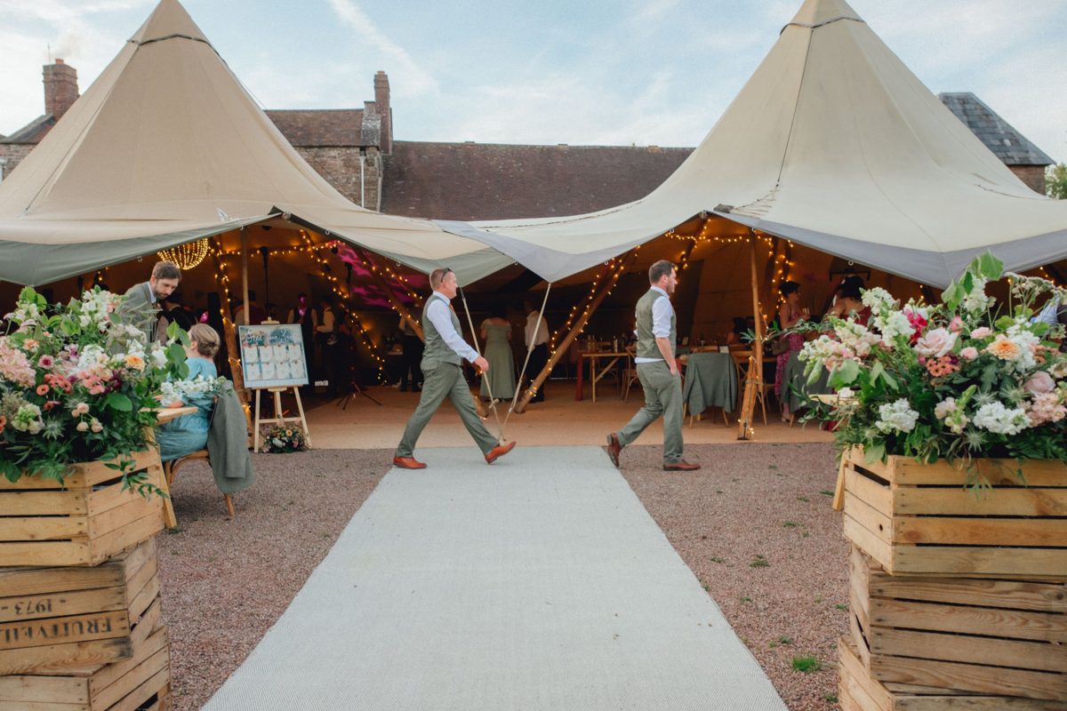 When you walk the walk. Walkway matting leading to two linked Java tipis, framed by wooden crates overflowing with flowers